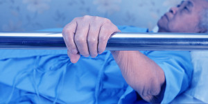 Patient holding on to bed rail.